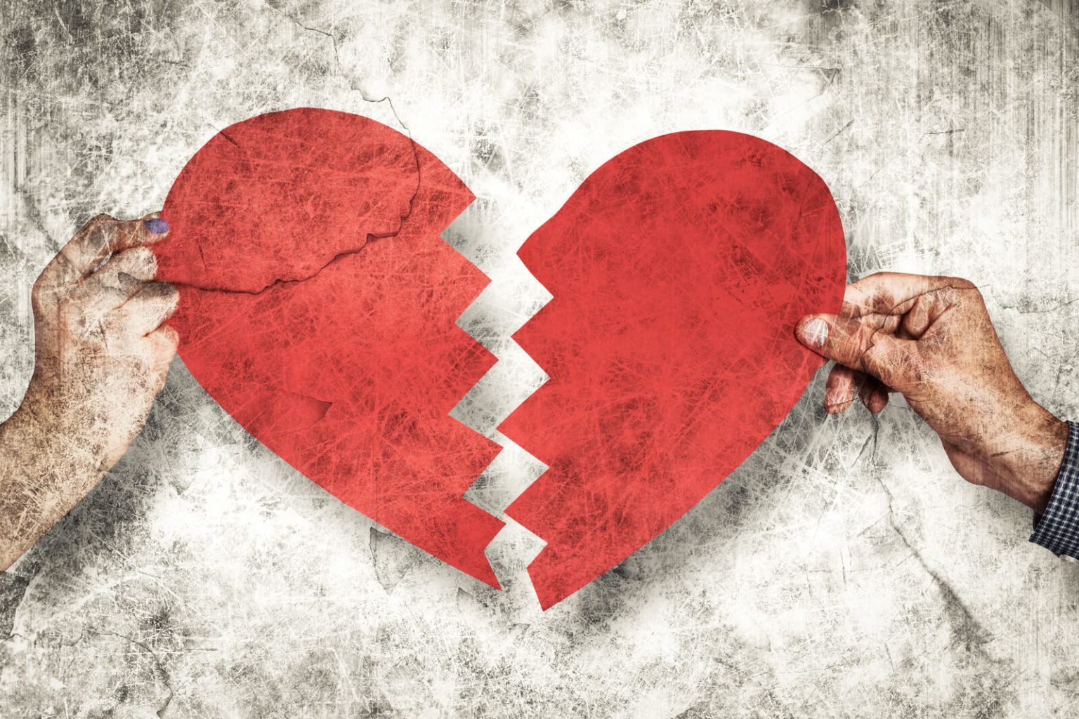 A paper heart being torn into two