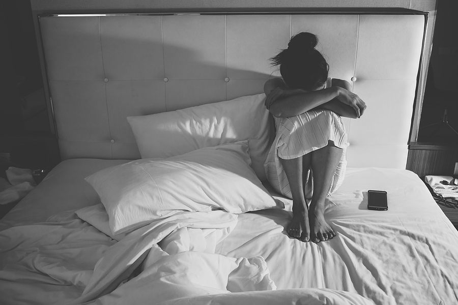 Woman crying on bed due to a recent loss