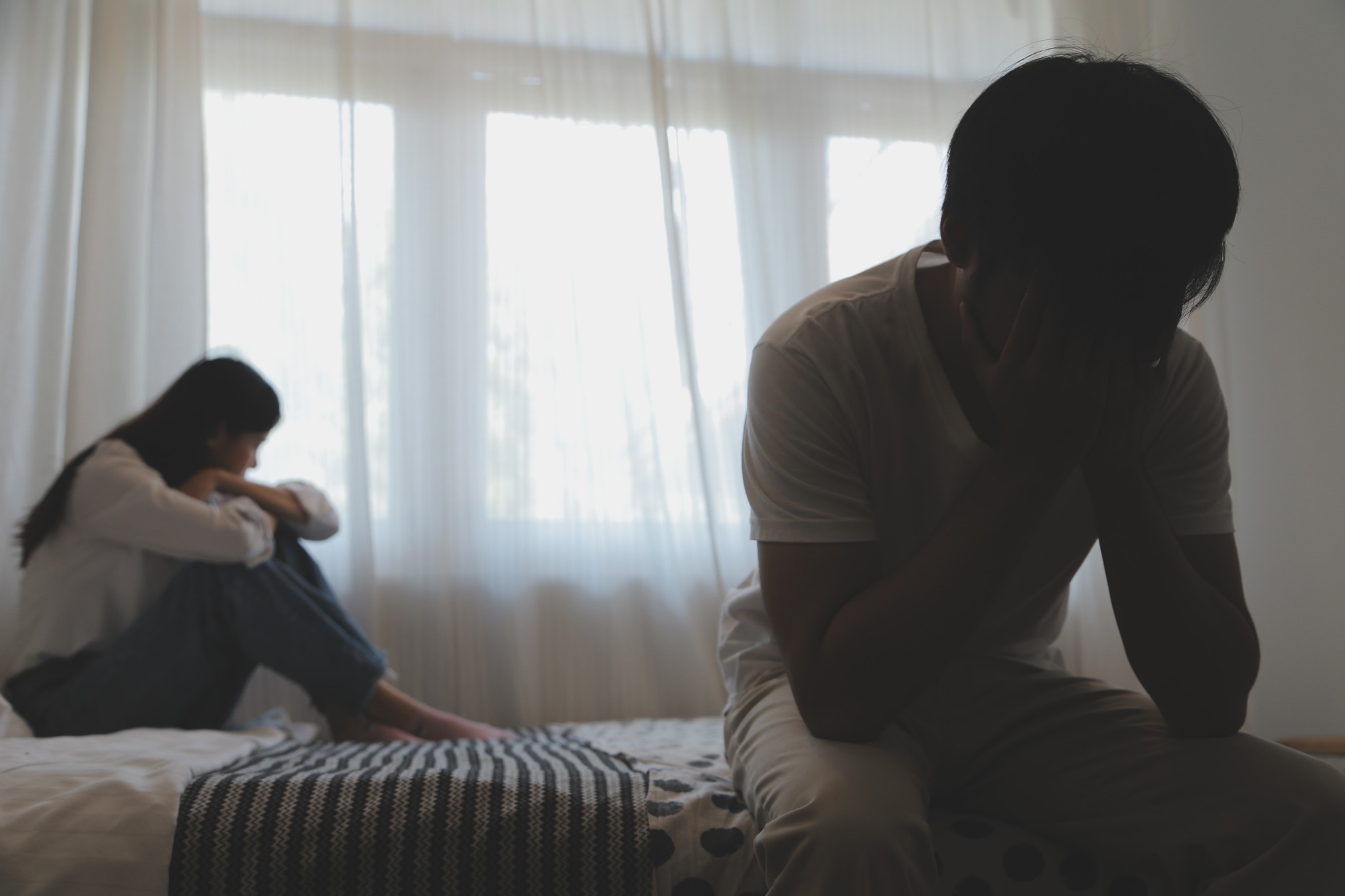 Couple covering their face stressed about infidelity