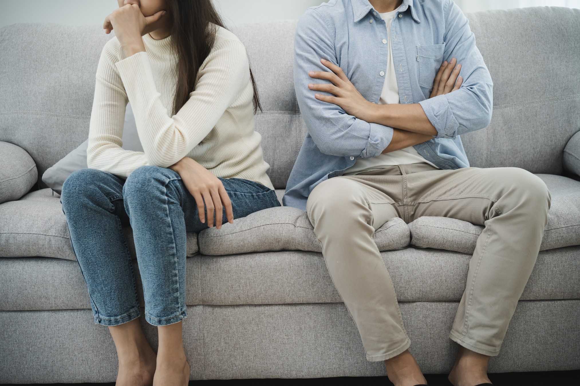 Couple sitting on couch fighting