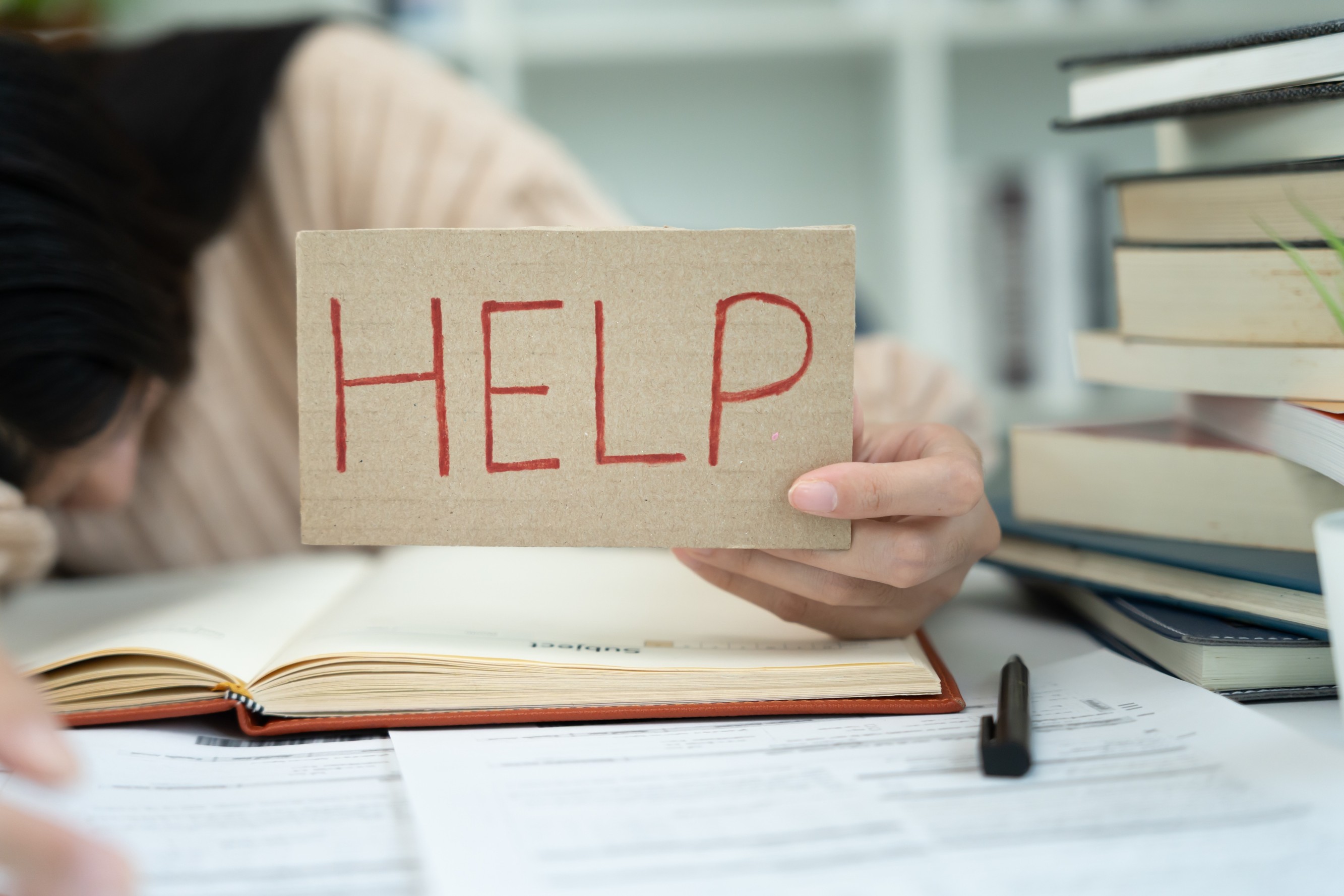 A sticky note on a laptop which spells 'HELP'